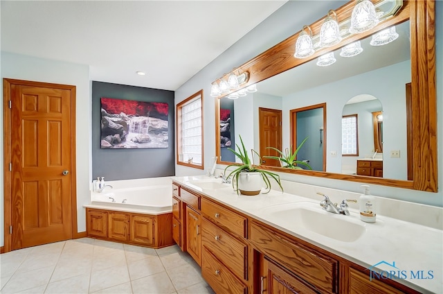 bathroom with a bathtub, vanity, and tile patterned flooring