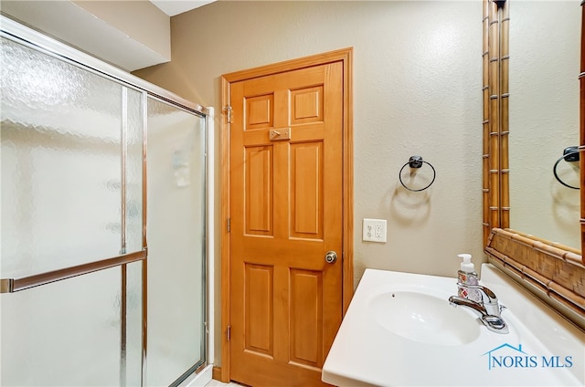 bathroom with vanity and a shower with shower door