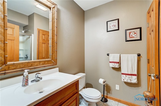 bathroom with tile patterned flooring, vanity, toilet, and a shower with shower door