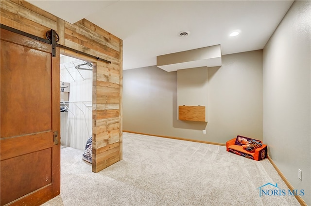 rec room featuring carpet and a barn door