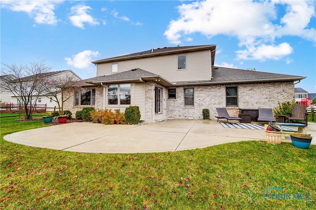 rear view of property featuring a yard and a patio