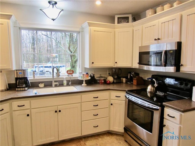 kitchen featuring white cabinetry, sink, and appliances with stainless steel finishes