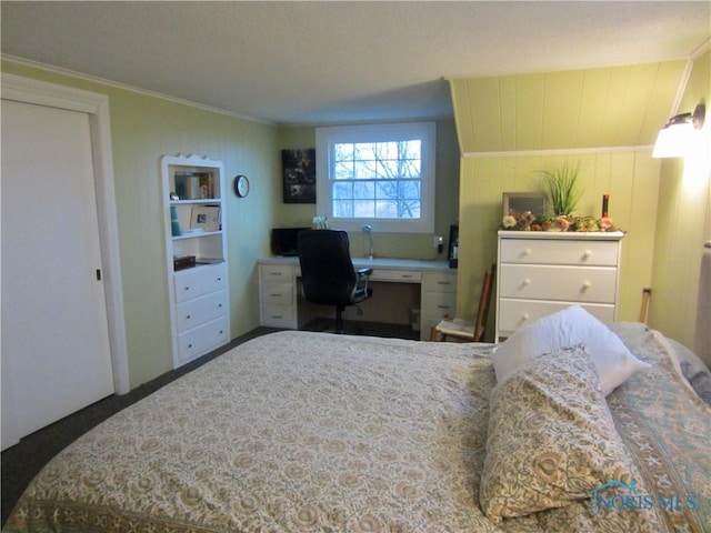 bedroom with built in desk and ornamental molding