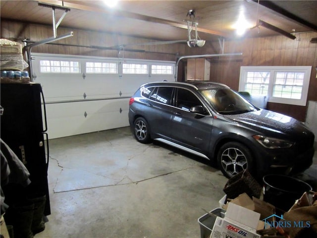 garage featuring a garage door opener and wood walls