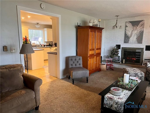 living room featuring light colored carpet, sink, and a brick fireplace