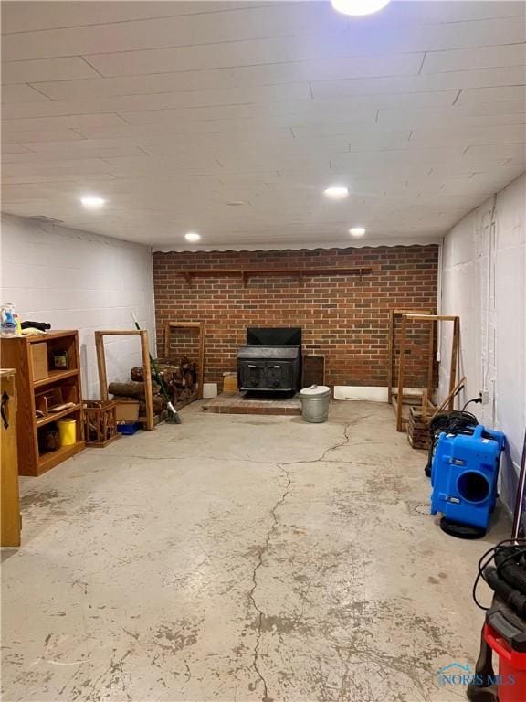 basement with a wood stove and brick wall