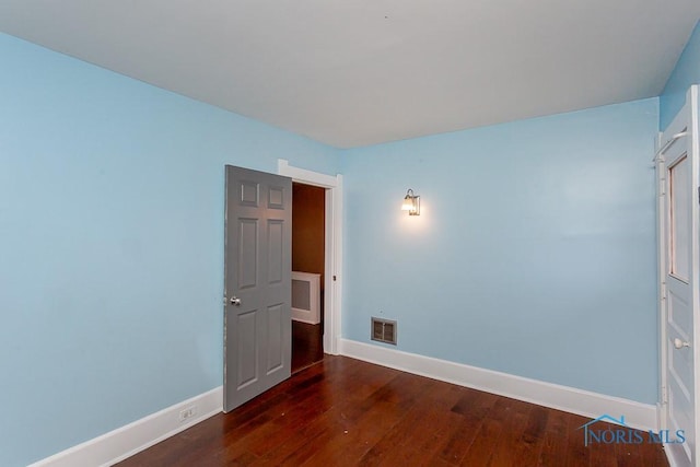 unfurnished room featuring dark hardwood / wood-style floors