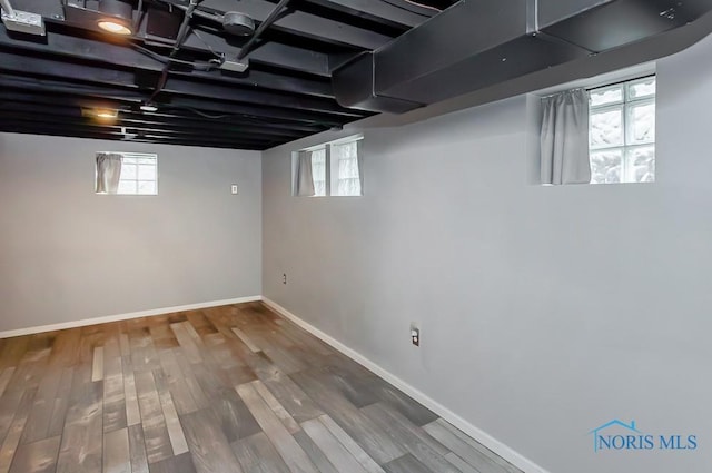 basement featuring plenty of natural light and hardwood / wood-style floors