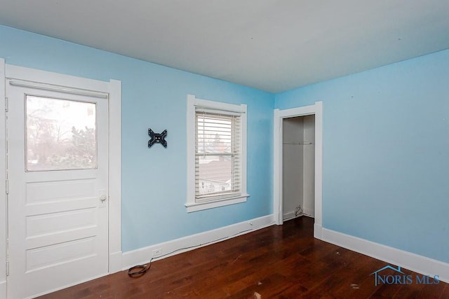 unfurnished bedroom with dark hardwood / wood-style floors and a closet