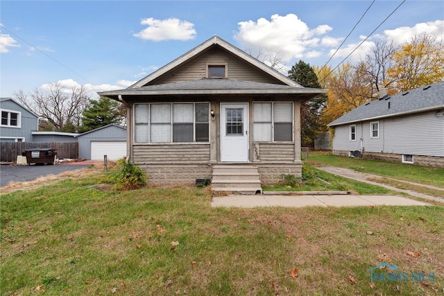 bungalow-style house featuring an outbuilding, a front yard, and a garage