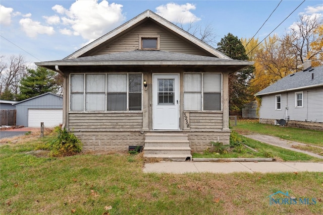 bungalow featuring an outbuilding, a front yard, and a garage