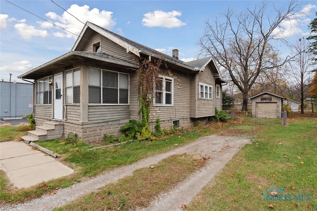 view of side of property with a yard, a garage, and an outdoor structure