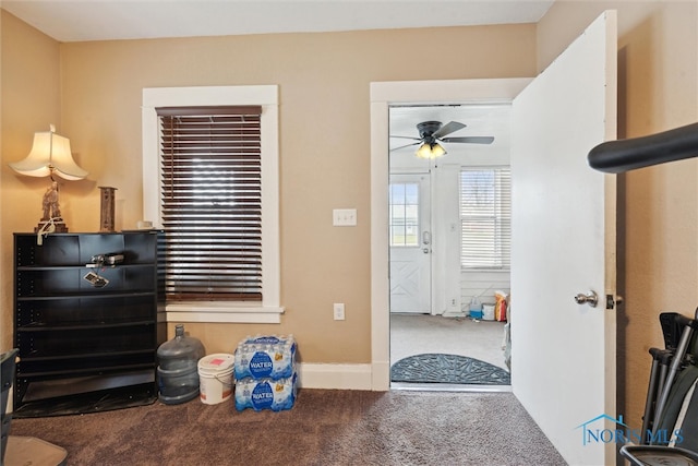 carpeted entrance foyer featuring ceiling fan