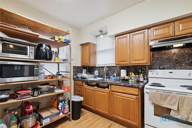 kitchen featuring backsplash, dark stone counters, sink, electric range, and light hardwood / wood-style floors