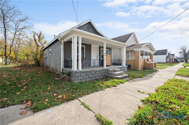 bungalow-style house with covered porch and a front yard