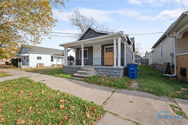 bungalow with a porch and a front yard