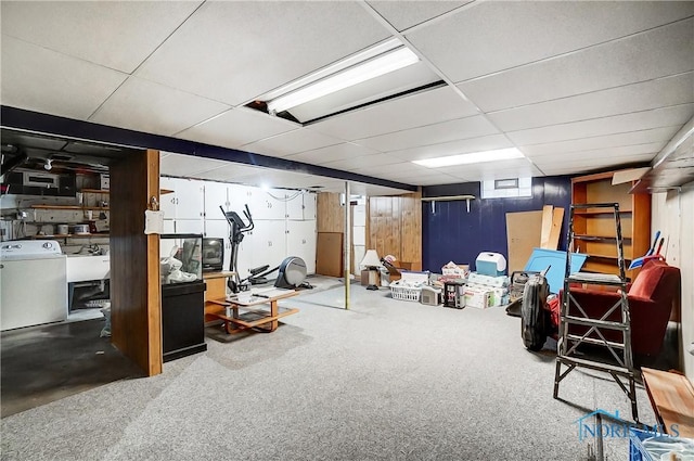 basement with sink, wood walls, washer / dryer, a paneled ceiling, and carpet