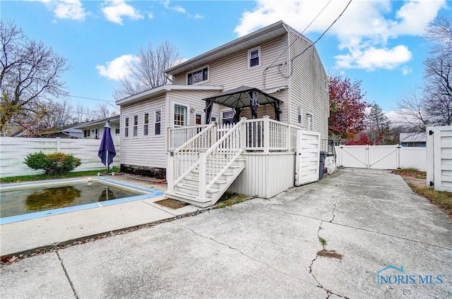 view of front of property with a gazebo and a swimming pool side deck