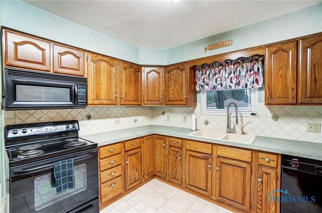 kitchen with decorative backsplash, sink, light tile patterned floors, and black appliances