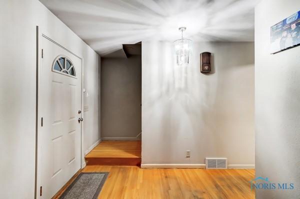 entrance foyer featuring hardwood / wood-style floors and a notable chandelier