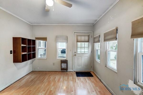 interior space with ceiling fan, light wood-type flooring, and ornamental molding