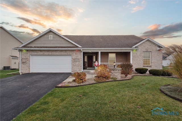 single story home featuring a yard, cooling unit, a porch, and a garage