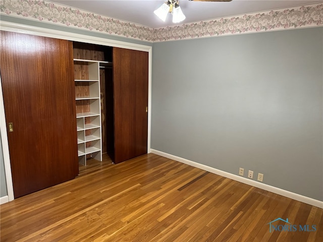 unfurnished bedroom with wood-type flooring, a closet, and ceiling fan