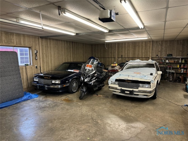 garage featuring a garage door opener and wood walls