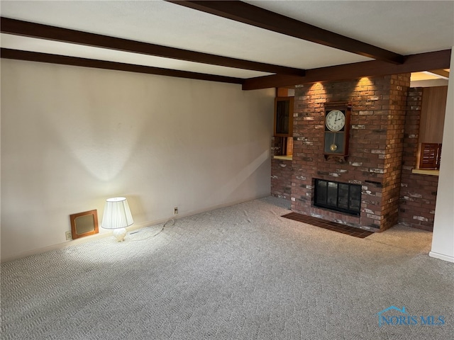 unfurnished living room with a fireplace, beamed ceiling, and carpet