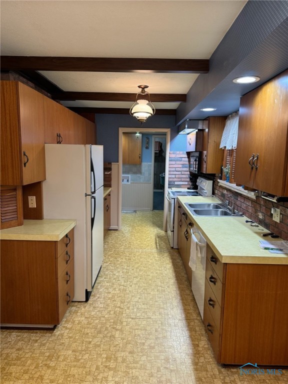 kitchen featuring beam ceiling, decorative backsplash, sink, and white appliances