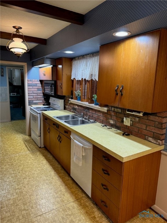 kitchen with beamed ceiling, white appliances, and sink