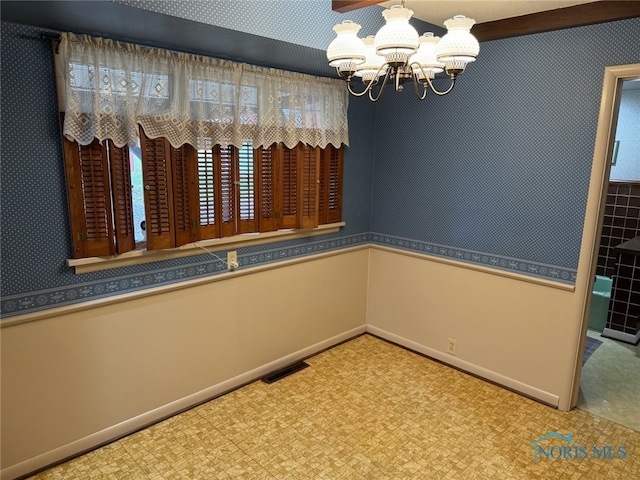 empty room featuring an inviting chandelier