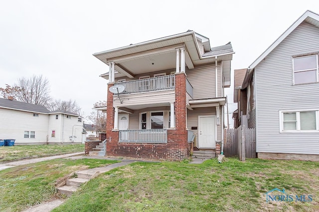 view of front of property with a balcony and a front lawn