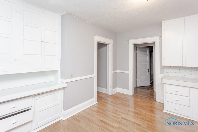 interior space featuring light hardwood / wood-style flooring and a textured ceiling