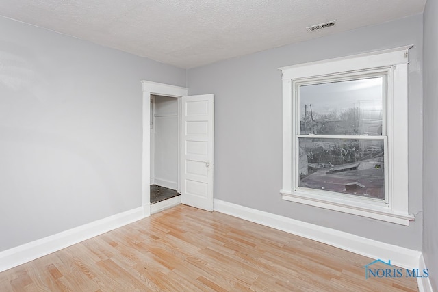 unfurnished bedroom with a textured ceiling and light wood-type flooring