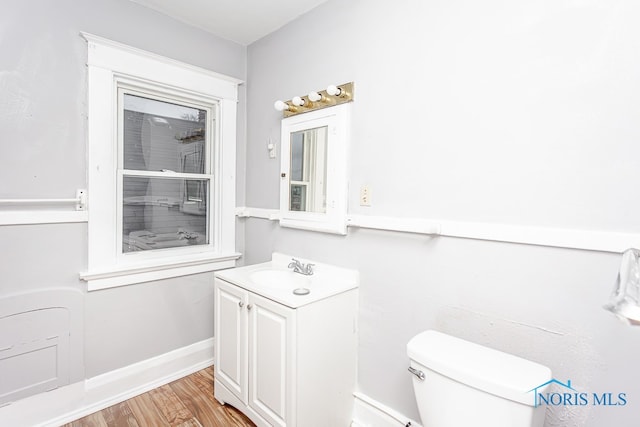 bathroom with toilet, vanity, and hardwood / wood-style flooring