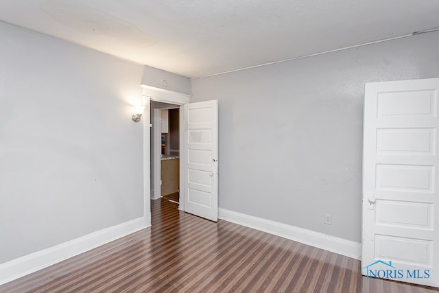 spare room with dark wood-type flooring