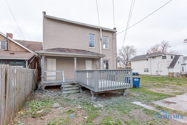 rear view of property featuring a wooden deck