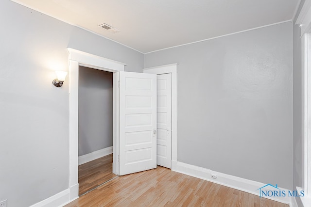 unfurnished bedroom featuring a closet and light wood-type flooring