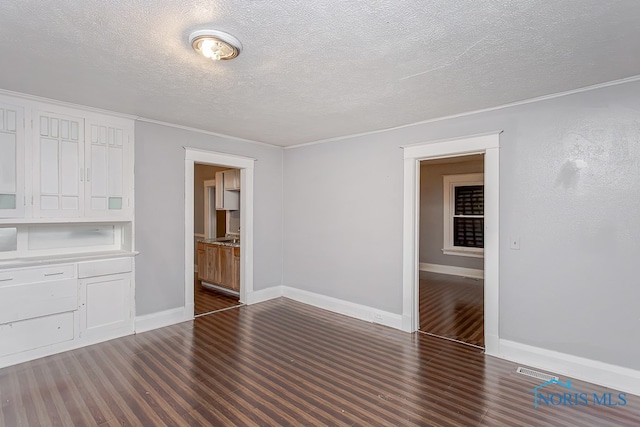 spare room with dark hardwood / wood-style flooring and a textured ceiling