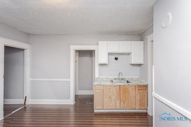 kitchen with white cabinetry, sink, dark wood-type flooring, and a textured ceiling