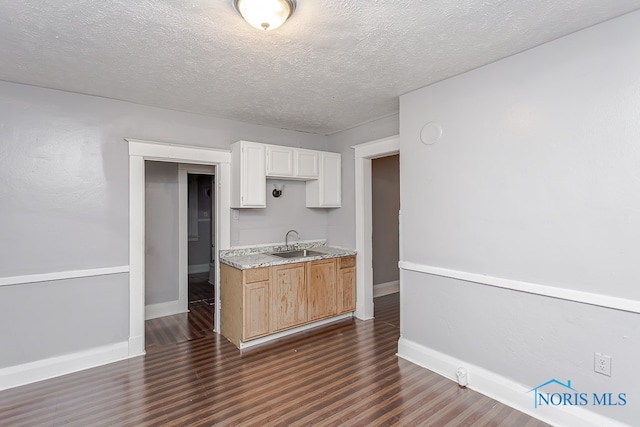 kitchen with white cabinetry, dark hardwood / wood-style flooring, a textured ceiling, and sink