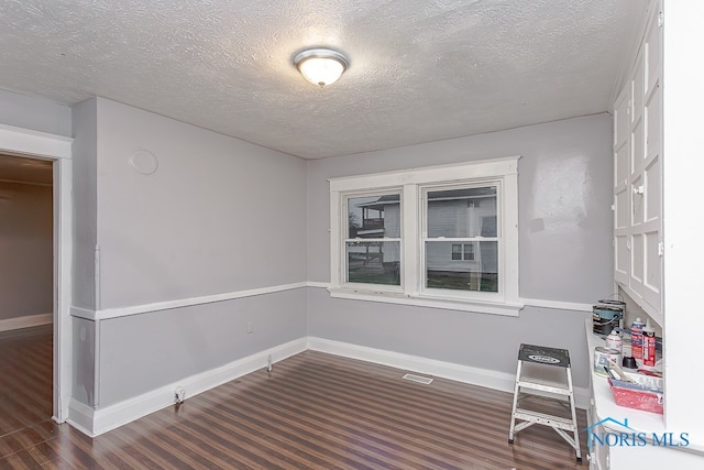 interior space featuring dark hardwood / wood-style floors and a textured ceiling