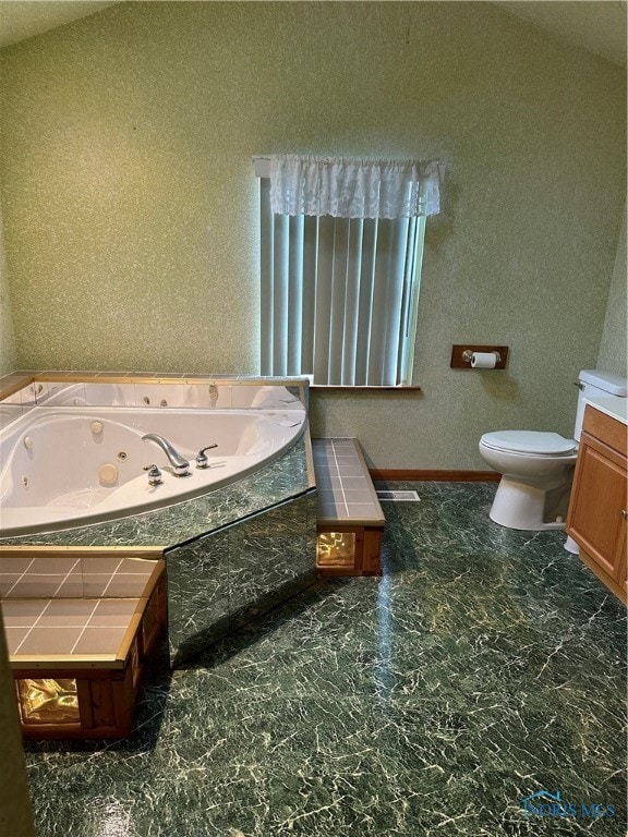 bathroom featuring toilet, tiled bath, and vaulted ceiling