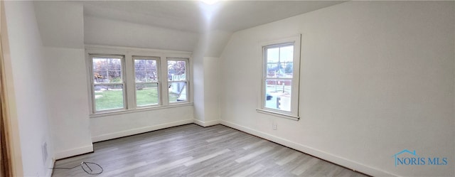 spare room with vaulted ceiling and light wood-type flooring