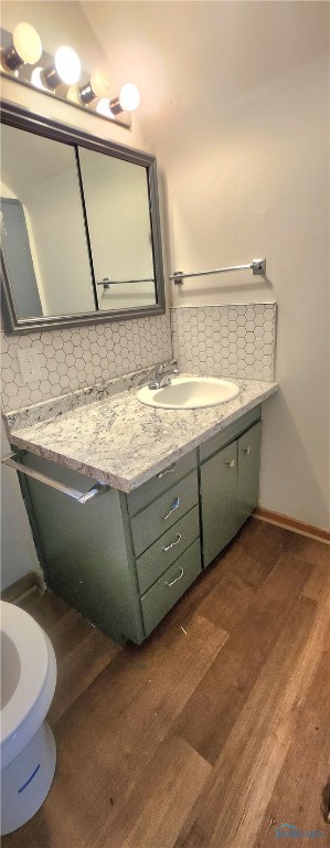 bathroom with decorative backsplash, wood-type flooring, and vanity