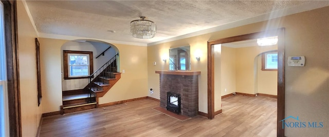 interior space featuring hardwood / wood-style floors, a chandelier, a textured ceiling, and ornamental molding