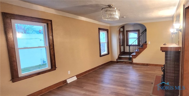 entryway featuring dark hardwood / wood-style floors, ornamental molding, and a chandelier