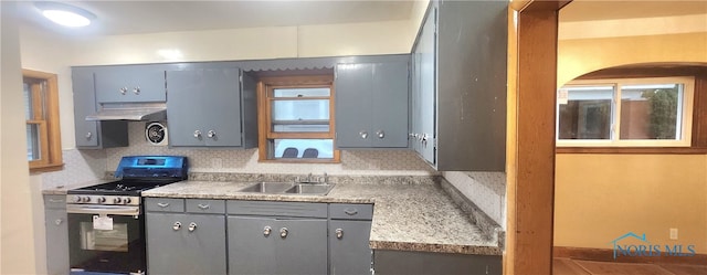 kitchen featuring gray cabinetry, sink, tasteful backsplash, range with gas cooktop, and ventilation hood