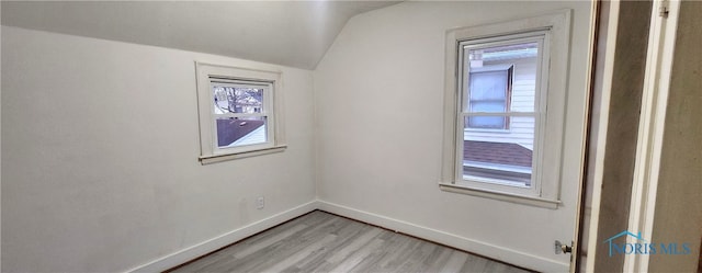 unfurnished room featuring light hardwood / wood-style flooring and lofted ceiling